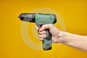 electric cordless screwdriver drill isolated on yellow background, professional home repair tool