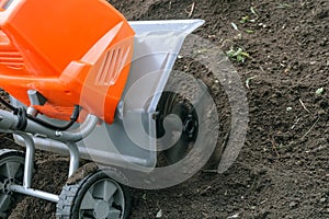 Electric cultivator cultivates soil in vegetable garden