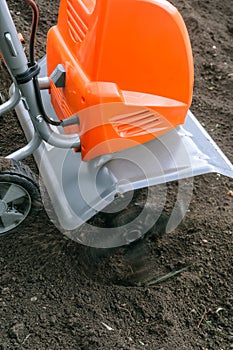 Electric cultivator cultivates soil in vegetable garden