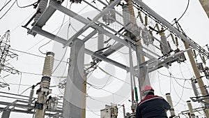 Electric energy work of power plant equipment by heavy industry worker in helmet