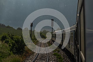Electric engine and blue coach from window in rainy day