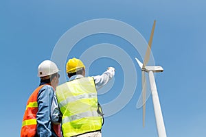 Electric Engineer writing report on Clipboard with Wind turbine