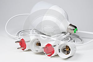 Electric European plug and lamp holder light bulb. White power cable with plug. Power cord close-up
