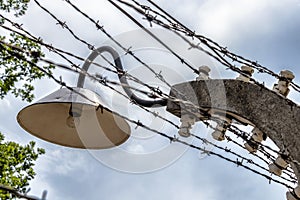 Electric fence with barbed wire and an old lamp