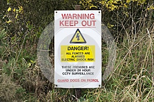 Electric fence and guard dog dangerous building construction site keep out health and safety signs