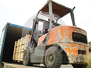 Electric Forklift Loading Cargos into Container