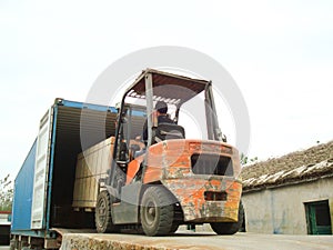 Electric Forklift Loading Cargos into Container