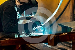 Electric and gas welder at work in a workshop at a welding enterprise