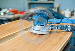 Electric grinder on a board in a carpentry workshop. Close-up