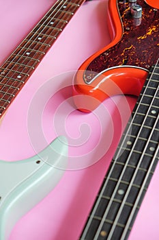 Electric guitar and bass guitar on a pink background