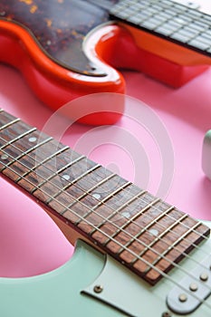 Electric guitar and bass guitar on a pink background