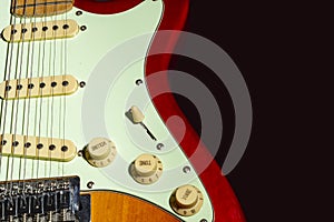 Electric guitar on a black background, isolated on a dark background in close-up. Selective focus