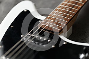 Electric guitar black and white color, detail. Music instruments. Concept international music day. Electrical guitar neck and meta