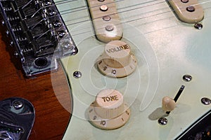 electric guitar bridge with volume and tone knobs and pickups