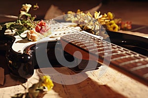 Electric guitar, dried flowers and rare notes closeup. Selective focus