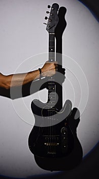 Electric guitar in male hand. Guitar player holds musical instrument