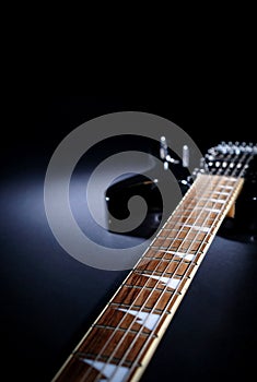 Electric guitar Stratocaster on a dark background under beam of light. with space for text