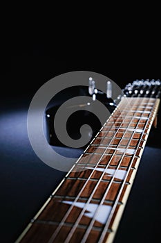 Electric guitar Stratocaster on a dark background under beam of light. With space for text