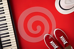 Electric guitar, synthesiser and red stylish sneakers, on red background