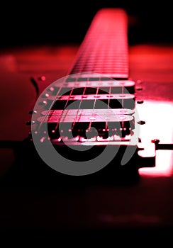 Electric guitar on wooden background. Retro music concept. Red shadows