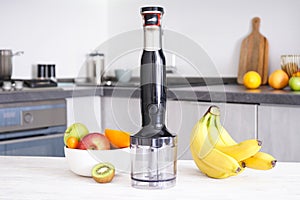 Electric hand mixer. Immersion hand blender on table on a kitchen background