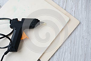 Electric hot glue gun on a wood background. the concept of repair or creativity background