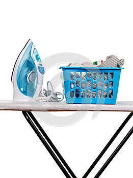 Electric iron and basket of clean linen on Ironing Board, isolated on white