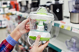 Electric juicer in hands of buyer at store