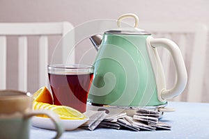 Electric kettle and cup of tea on table