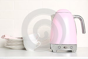 Electric kettle and dishes on counter in kitchen