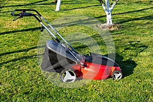 Electric Lawn mower on a green meadow. Garden equipment
