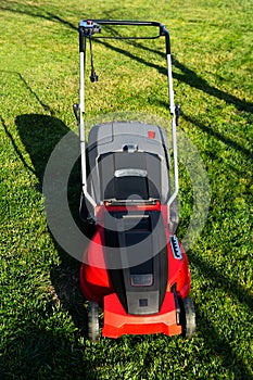 Electric Lawn mower on a green meadow. Garden equipment