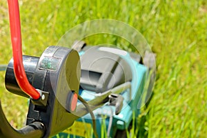 Electric lawn mower handle with red power button