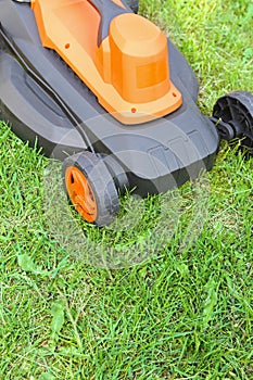Electric lawnmower on green grass