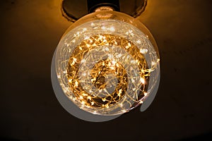 Electric light lamps in glass circle shape hanging on ceiling interior background