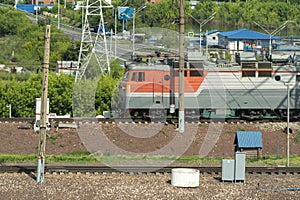 An electric locomotive on the railroad tracks near the river bank.