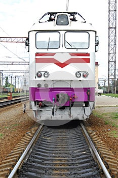 Electric locomotive of white color stands on rails