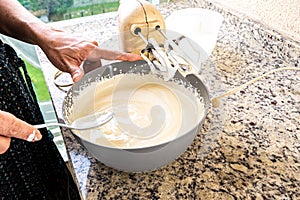Electric mixer being used to prepare cheesecake ingredients