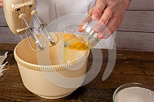 Electric mixer and eggs in a glass bowl