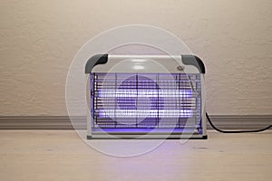 Electric Mosquito and Insect Zapper With Blue Purple Lights Turned on. Bug Killer Lamp on