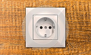 Electric outlet on wooden wall in house interior close-up, EU socket photo