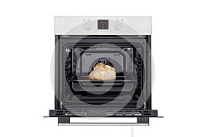 Electric oven with open door, lights on and baked white bread. Front view. Isolated on white