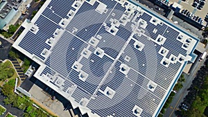 Electric photovoltaic solar panels installed on shopping mall building rooftop for production of green ecological