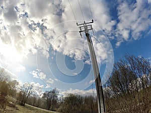 Electric pillar and wires in the field in the spring