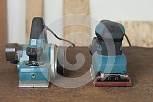 Electric planer and electric sheet finishing sander on old rusty metal sheet