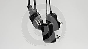 Electric plugs with electrical appliance cords in hand rising up on a white background.