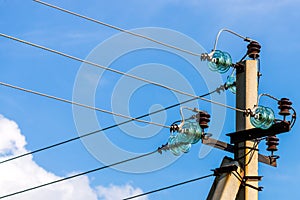 Electric pole against the blue clear sky. Three-phase power line to turn