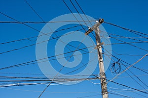 Electric pole with cables tangled in an anarchic way photo