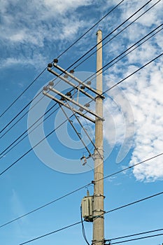 Electric pole and electric transformer with a clear blue sky background in portrait format