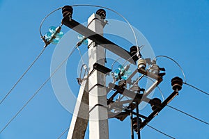 Electric pole. Electrical post with power line cables. Power lines and wires against bright blue sky